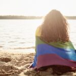 Rear view of young woman covered with rainbow flag